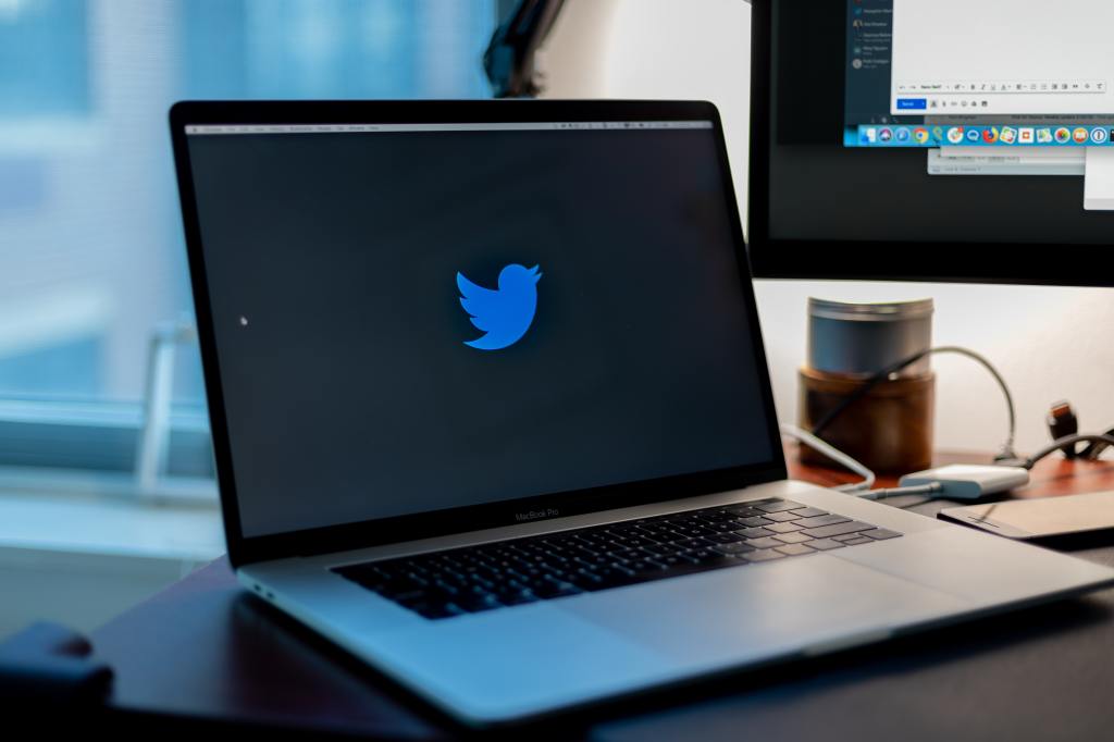 An open. laptop with a black screen showing the Twitter logo. 