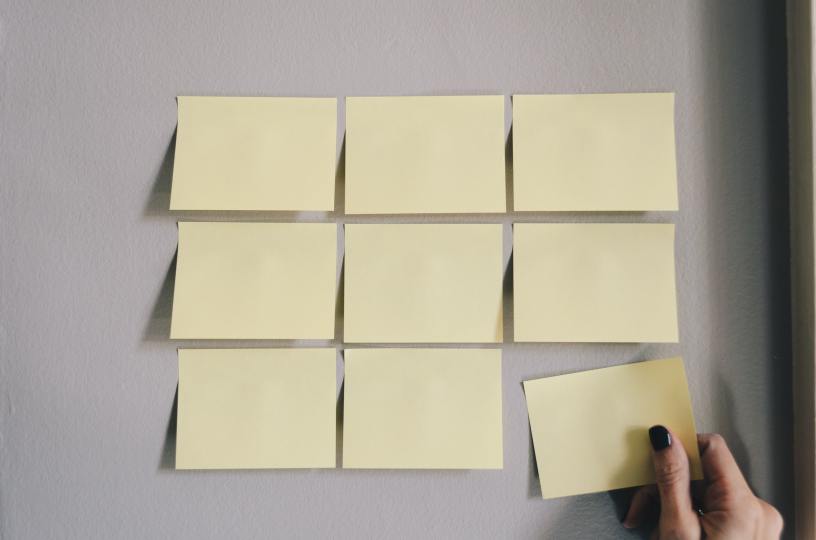 9 empty post it notes on a wall.