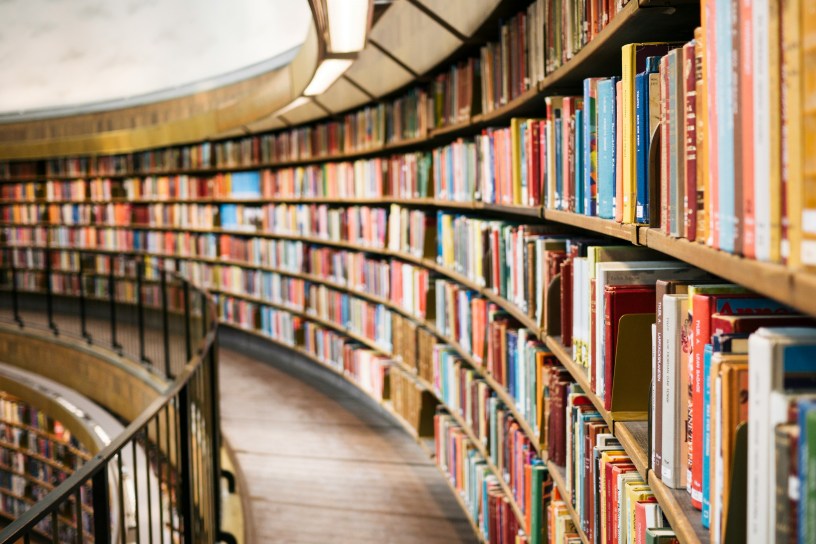 A curved bookcase in a library.